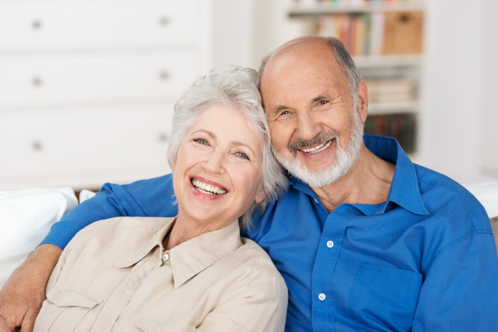 Smiling older couple who got dentures in just one day at the Anchorage, AK office of Dentures Alaska.